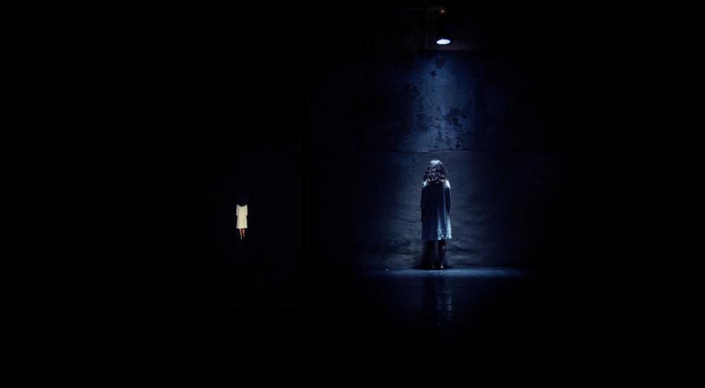 A person under a spotlight in a dark room 