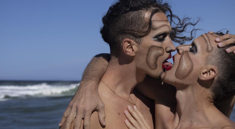 Pablo and Fede kissing in front of the ocean