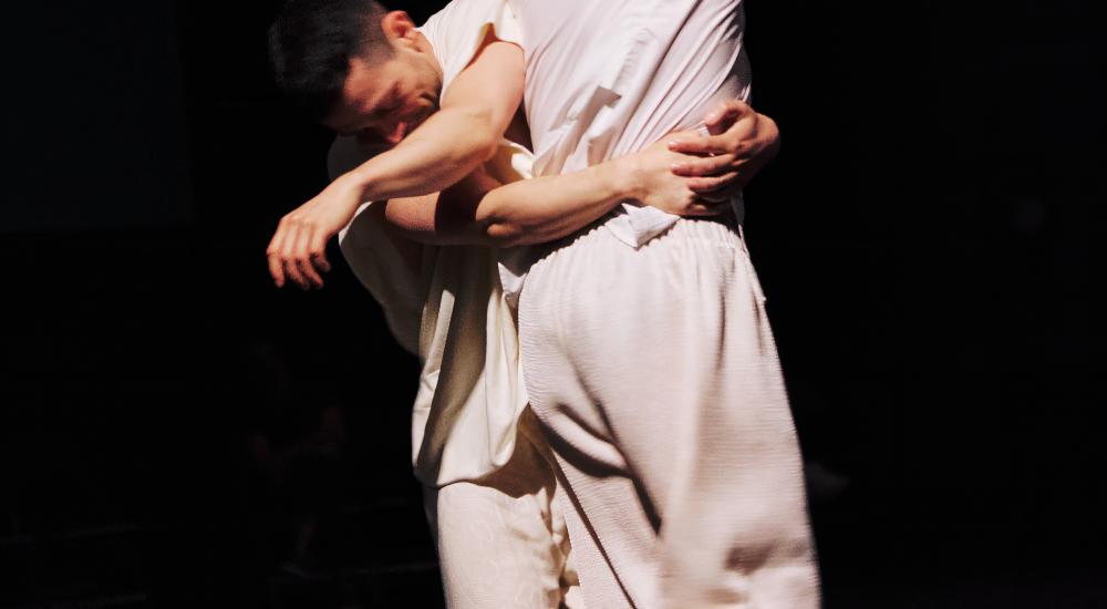 two dancers wrapped closely around each other