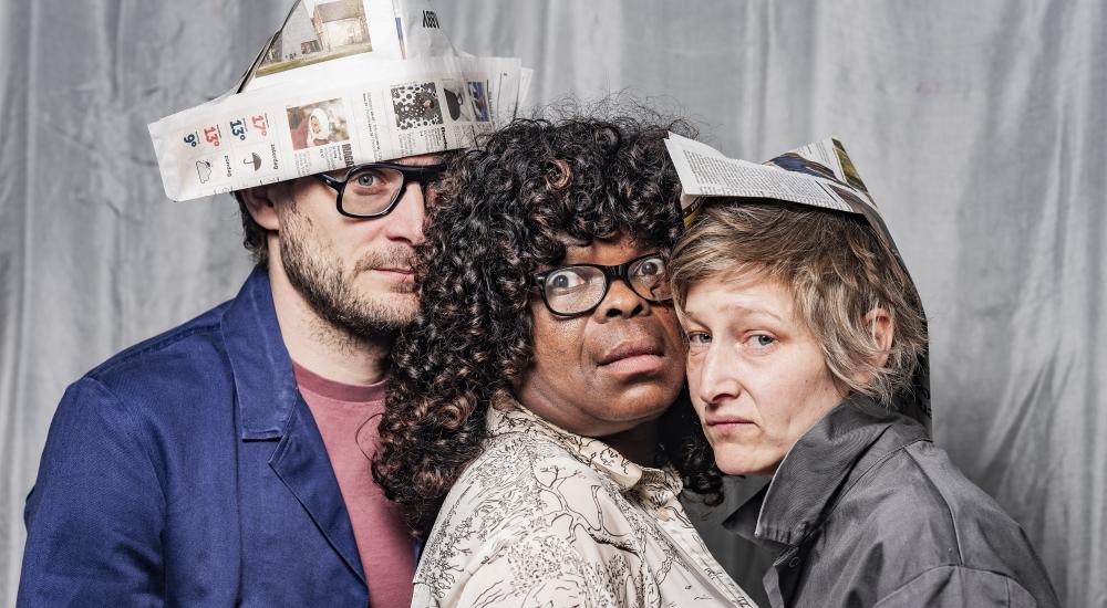 Starlette standing between Michiel (left) and Aurelie (right) wearing paper hats