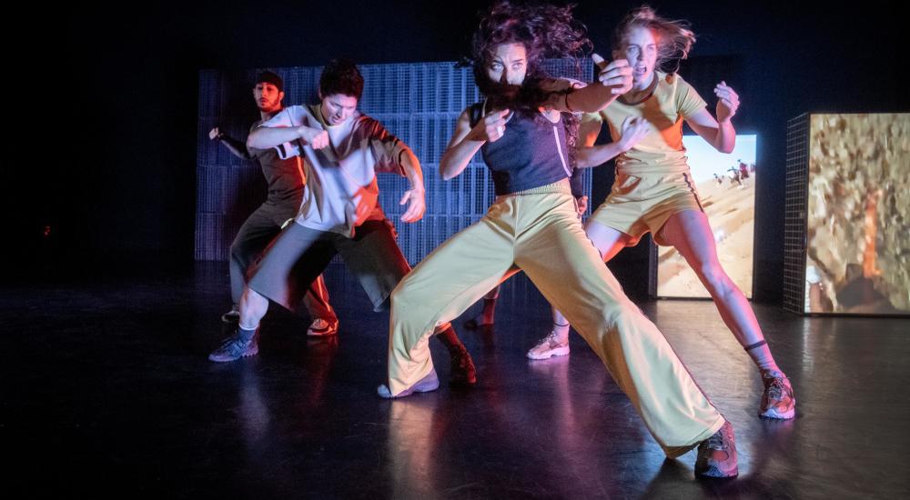 four performers on stage dancing