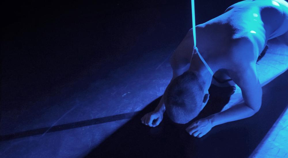 bending naked body covered with blue light