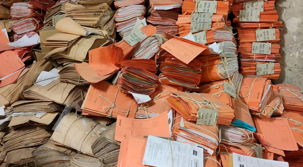 A big stack of papers in orange binders at the Palace of Justice
