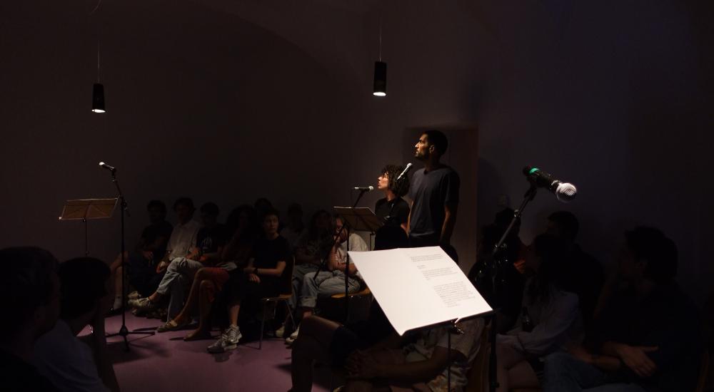 two people standing in a room behind an microphone