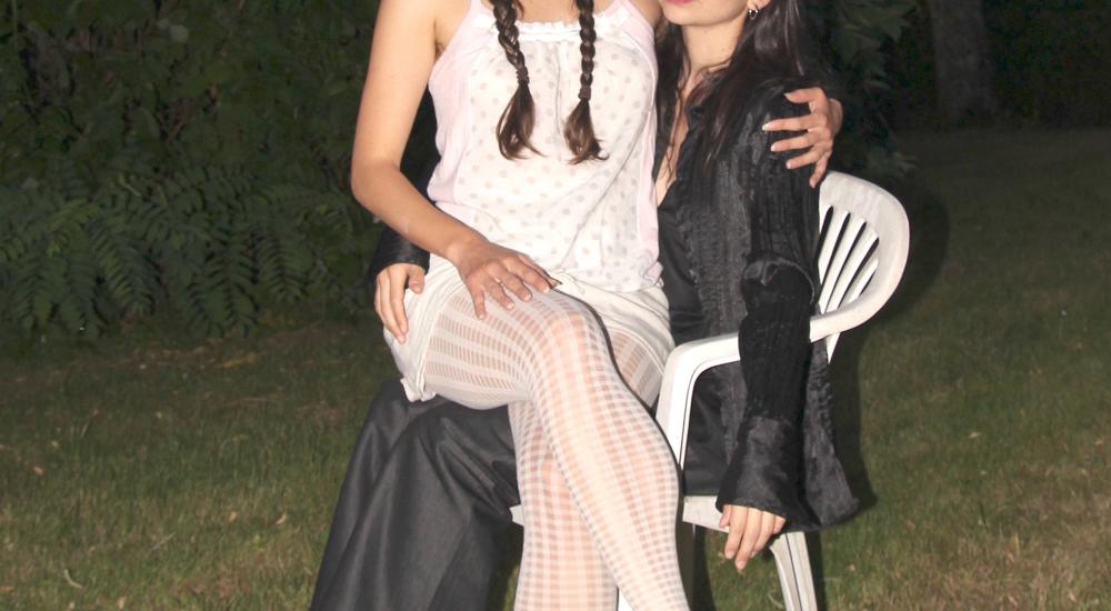 Luisa sitting on Estefania's lap in a white plastic chair