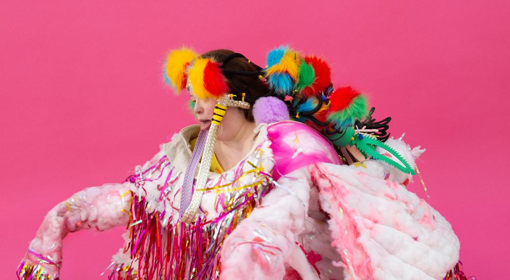 foto Laetitia Bica een gehurkte persoon in een kleurrijk kostuum