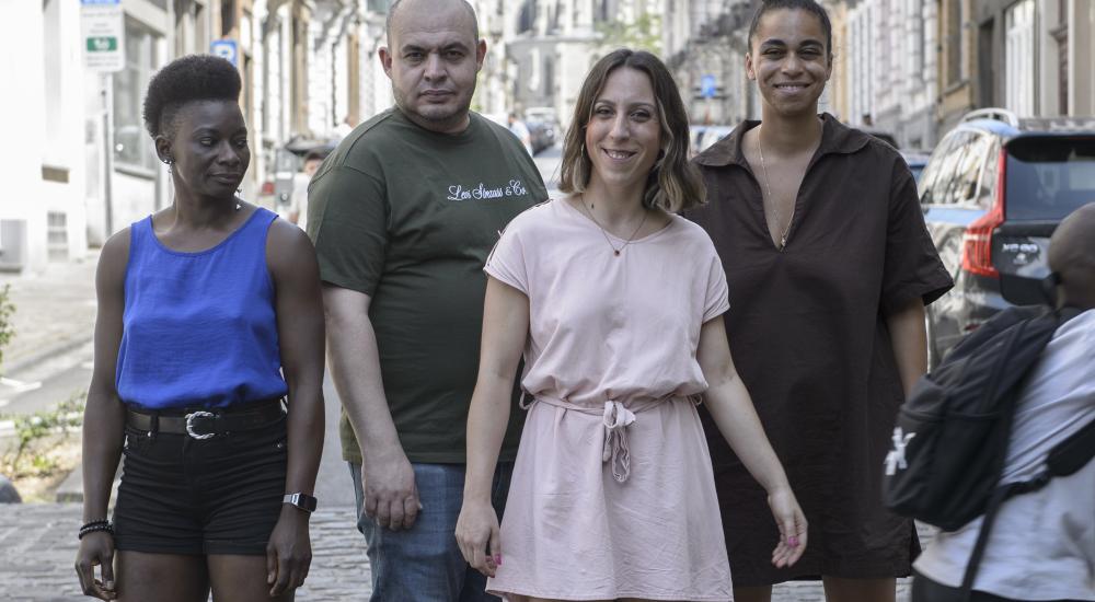 For people posing on the street while someone on an electric scooter rides by