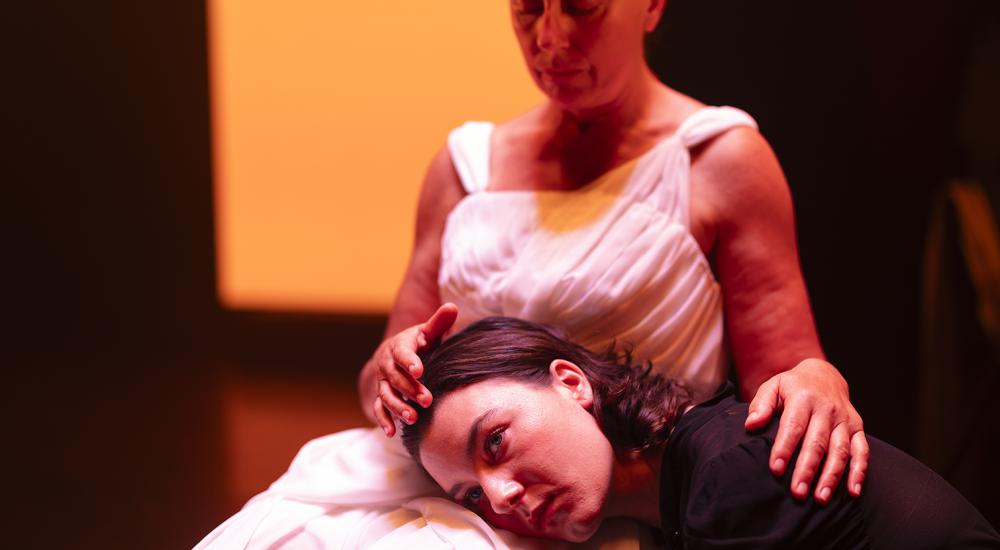 two actors sitting on stage
