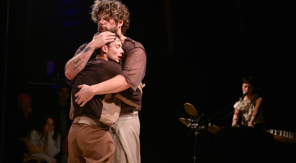 twee performers die elkaar in de armen sluiten