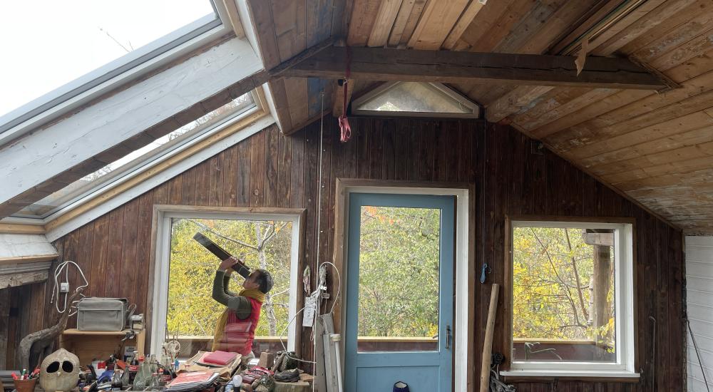 houten huisje persoon kijkt door verrekijker
