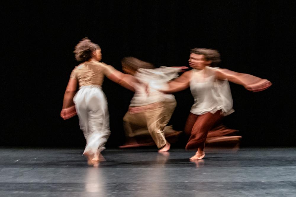 Blurry photo showing three dancers in movement