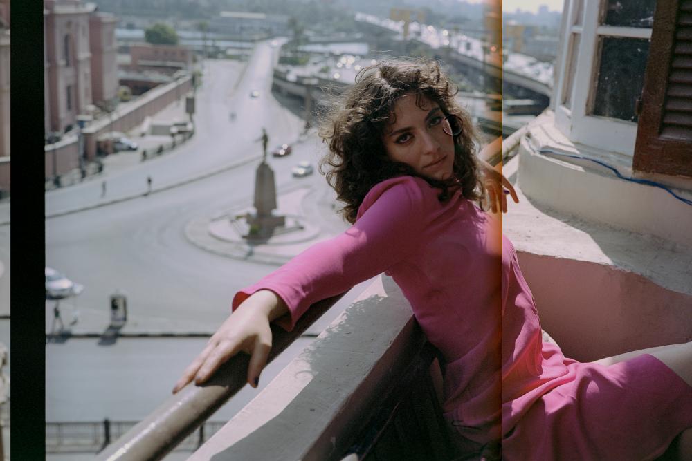 Nadah El Shazly on a balcony overlooking a roundabout with a statue in the middle