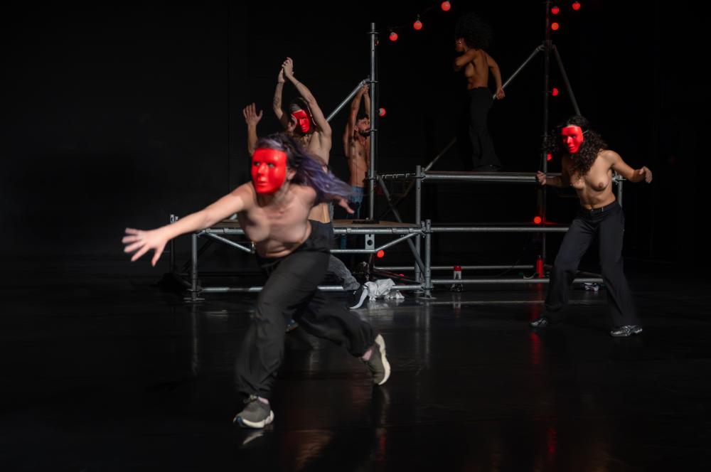 Three dancers wearing red masks