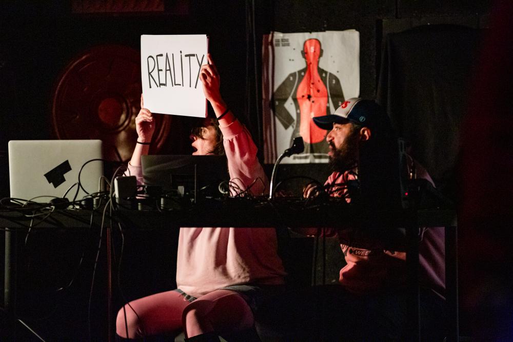 A person holding a sign that say Reality