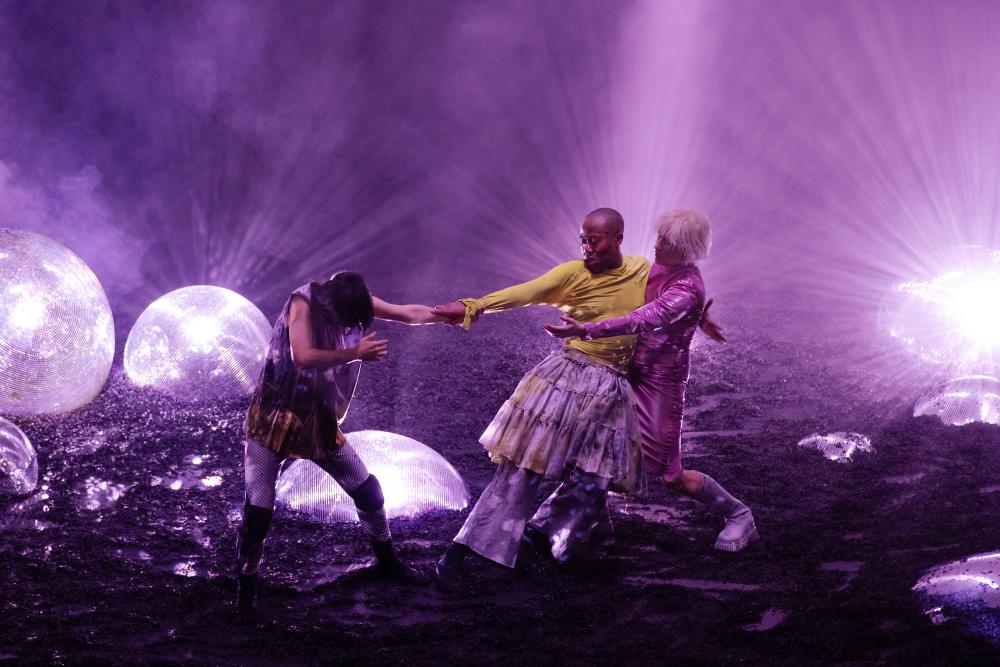 The three of them in front of purple lighting