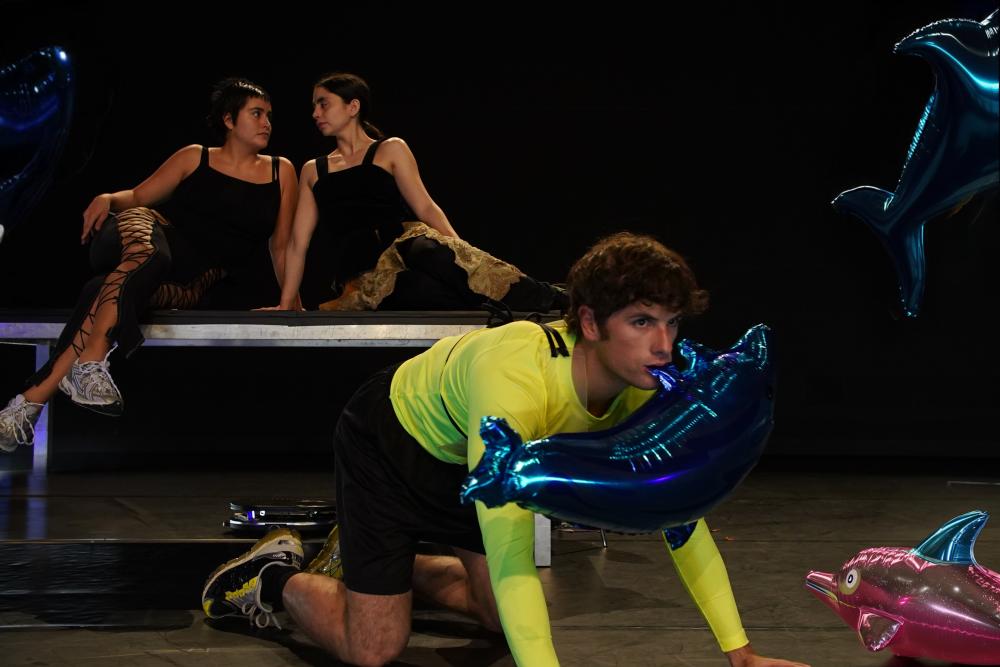A male dancer on his knees with a blow-up whale in his mouth