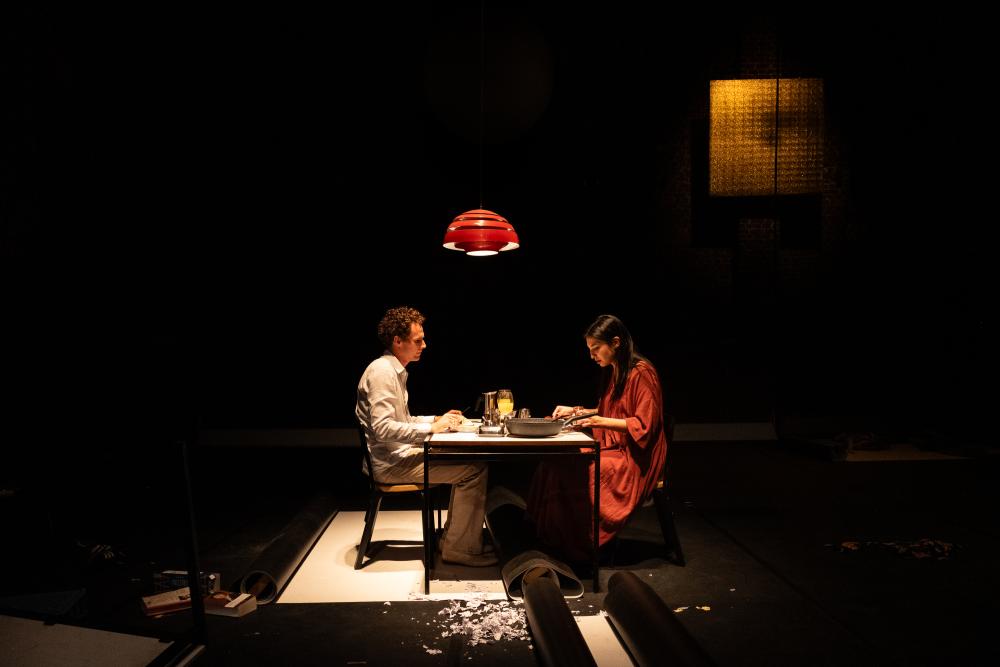 April and Frank sitting at a sparsely lit table