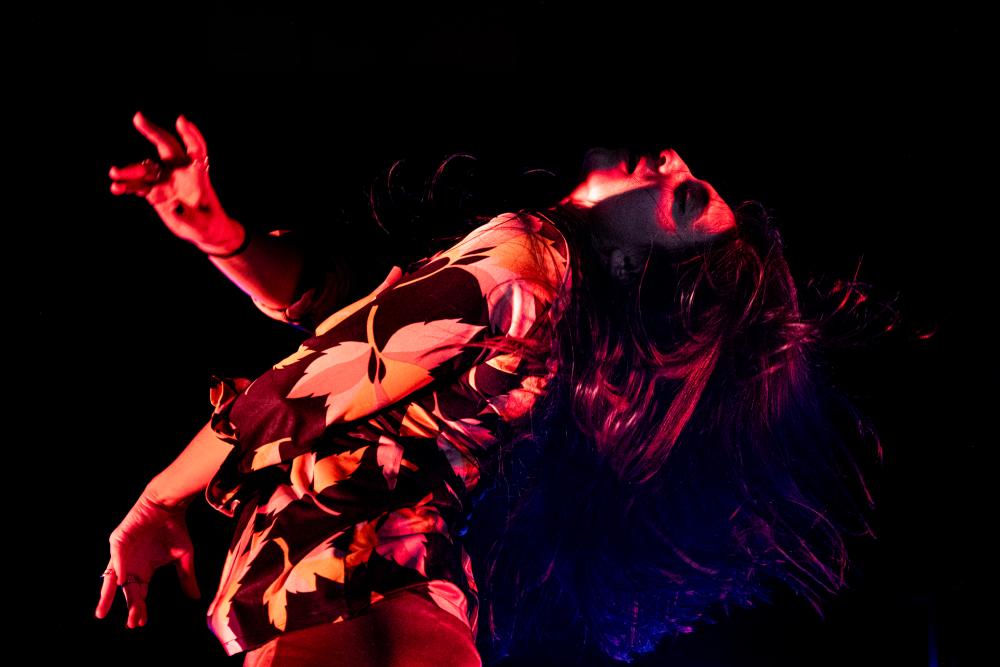 A woman with her head thrown back with red lighting