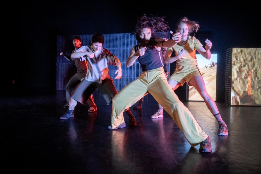 four performers on stage dancing