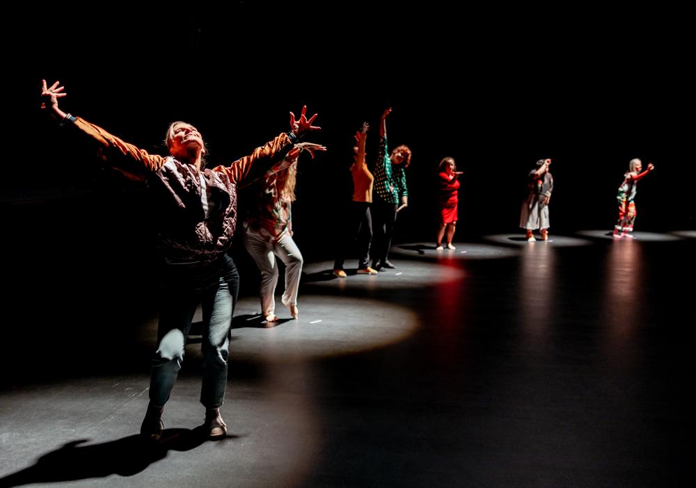 Dancers with their arms spread wide open