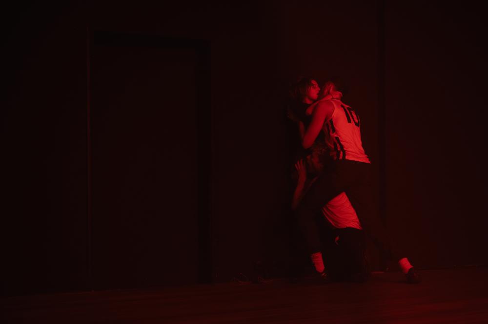 Two people embracing under red light