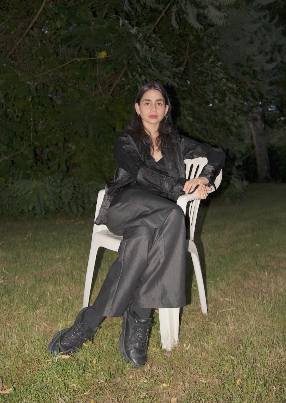Estefania sitting on a white plastic chair