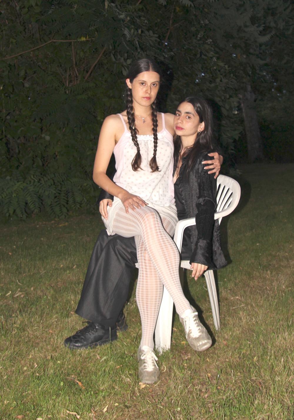 Luisa sitting on Estefania's lap in a white plastic chair