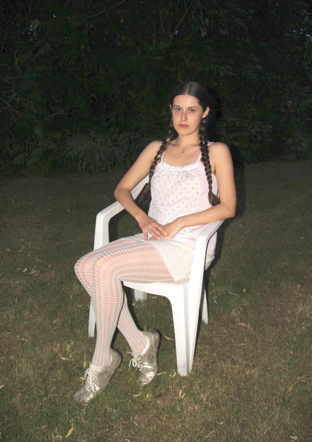 Luisa sitting on a white plastic chair