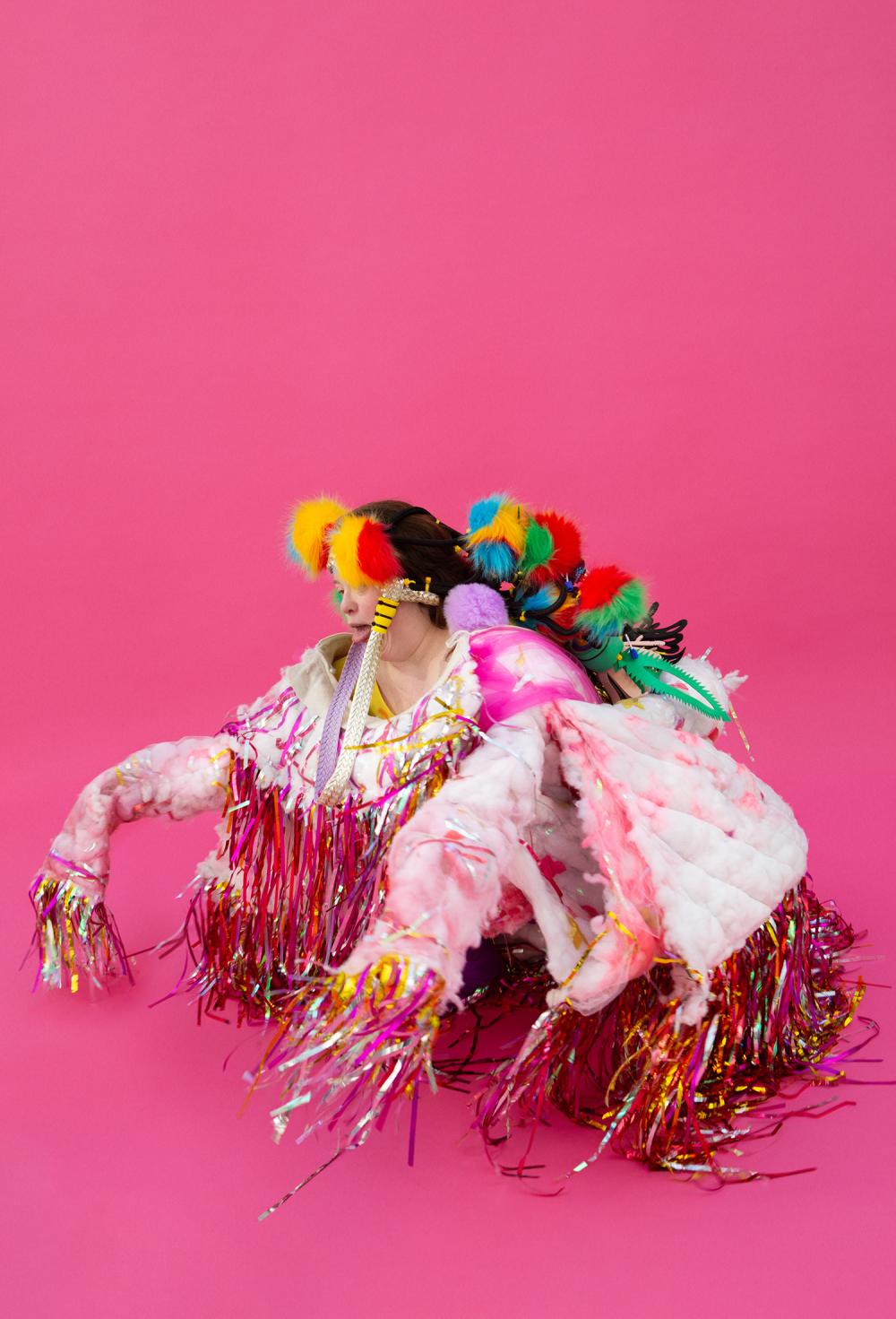 foto Laetitia Bica een gehurkte persoon in een kleurrijk kostuum