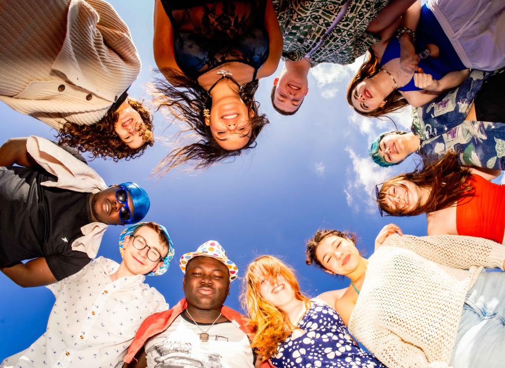 The cast of the beach looking down at the camera