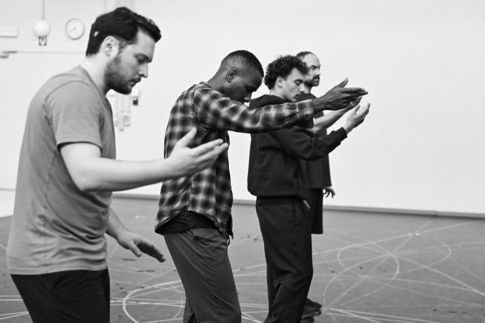 four dancers holding out their hands