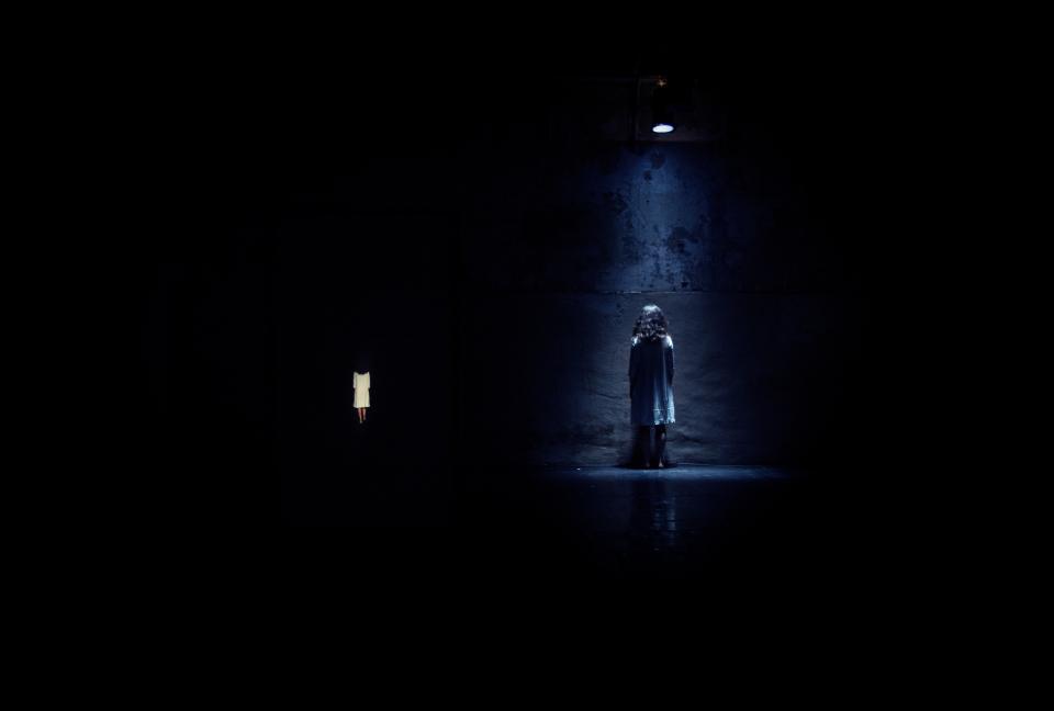 A person under a spotlight in a dark room 