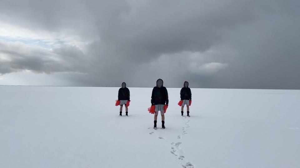 Three people standing in snow