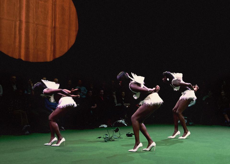 Three dancers wearing wings 