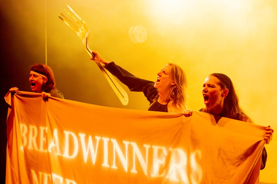 people with a banner 'breadwinners' and a giant fork