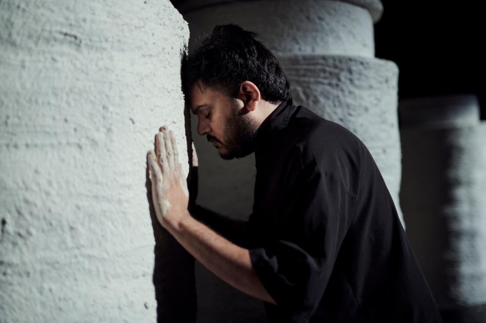 man leaning his head on a wall eyes closed