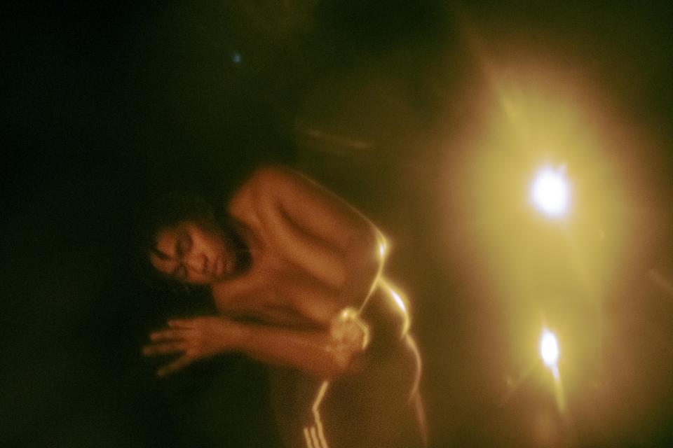 Black person bending sideway on stage