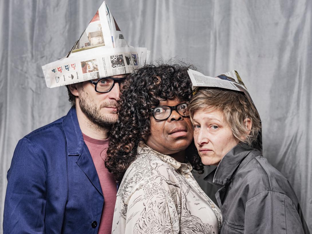 Starlette standing between Michiel (left) and Aurelie (right) wearing paper hats