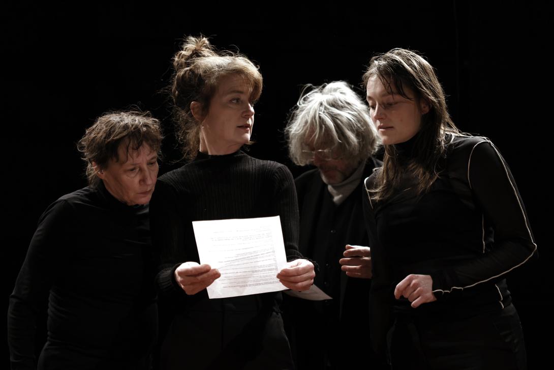 Three women and an man looking at a text 